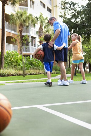 En basketplan med en byggnad i bakgrunden.