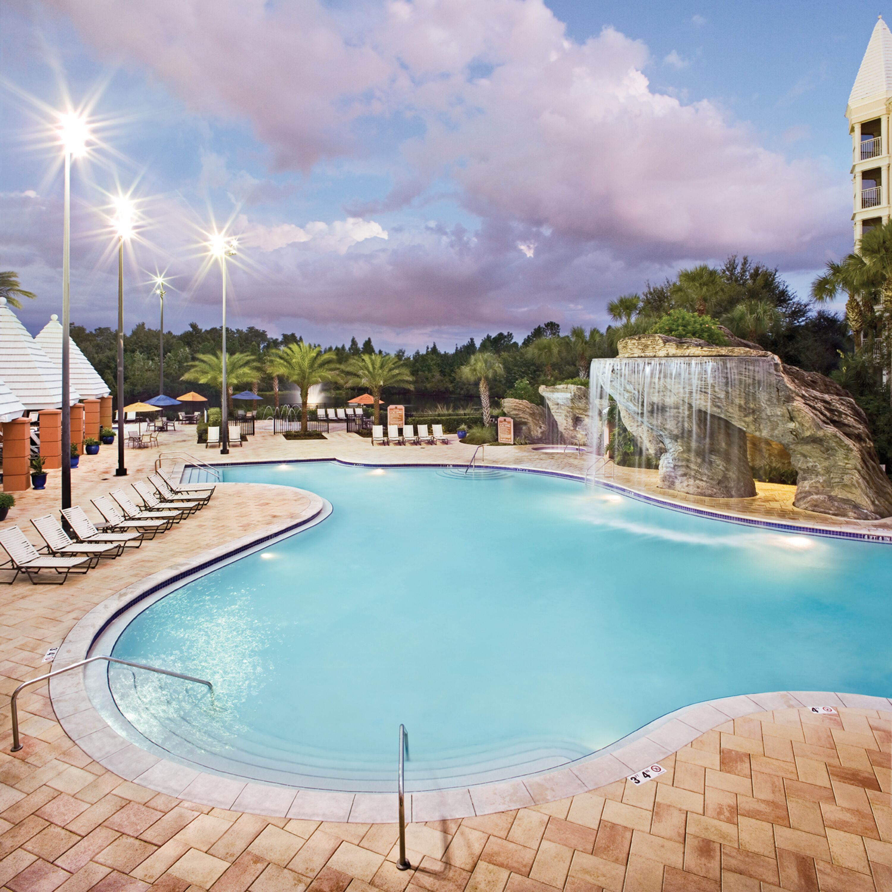 En swimmingpool med liggestole og klippeformation.