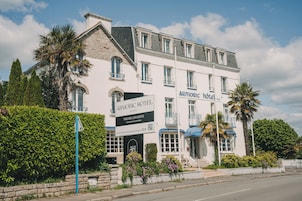 Un edificio blanco con balcones y un letrero que dice 'ARMORIC HOTEL'.