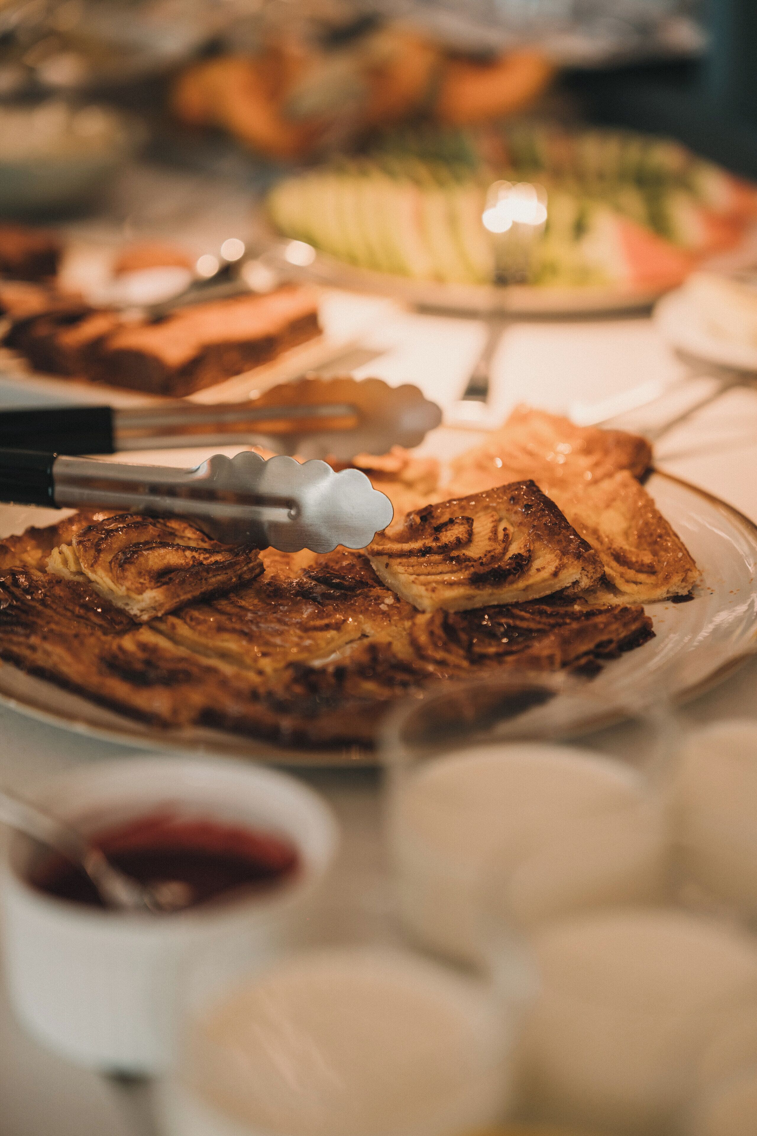 Un buffet proposant divers plats, notamment un grand plat de viande grillée et plusieurs bols de sauces.