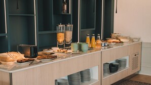 Een buffetopstelling met diverse soorten eten, drinken en bakken op een toonbank.