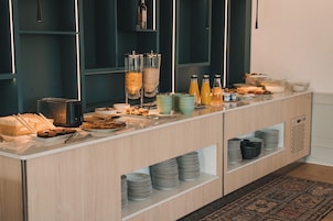 Un buffet proposant une variété de plats, de boissons et de récipients, le tout disposé sur un comptoir.
