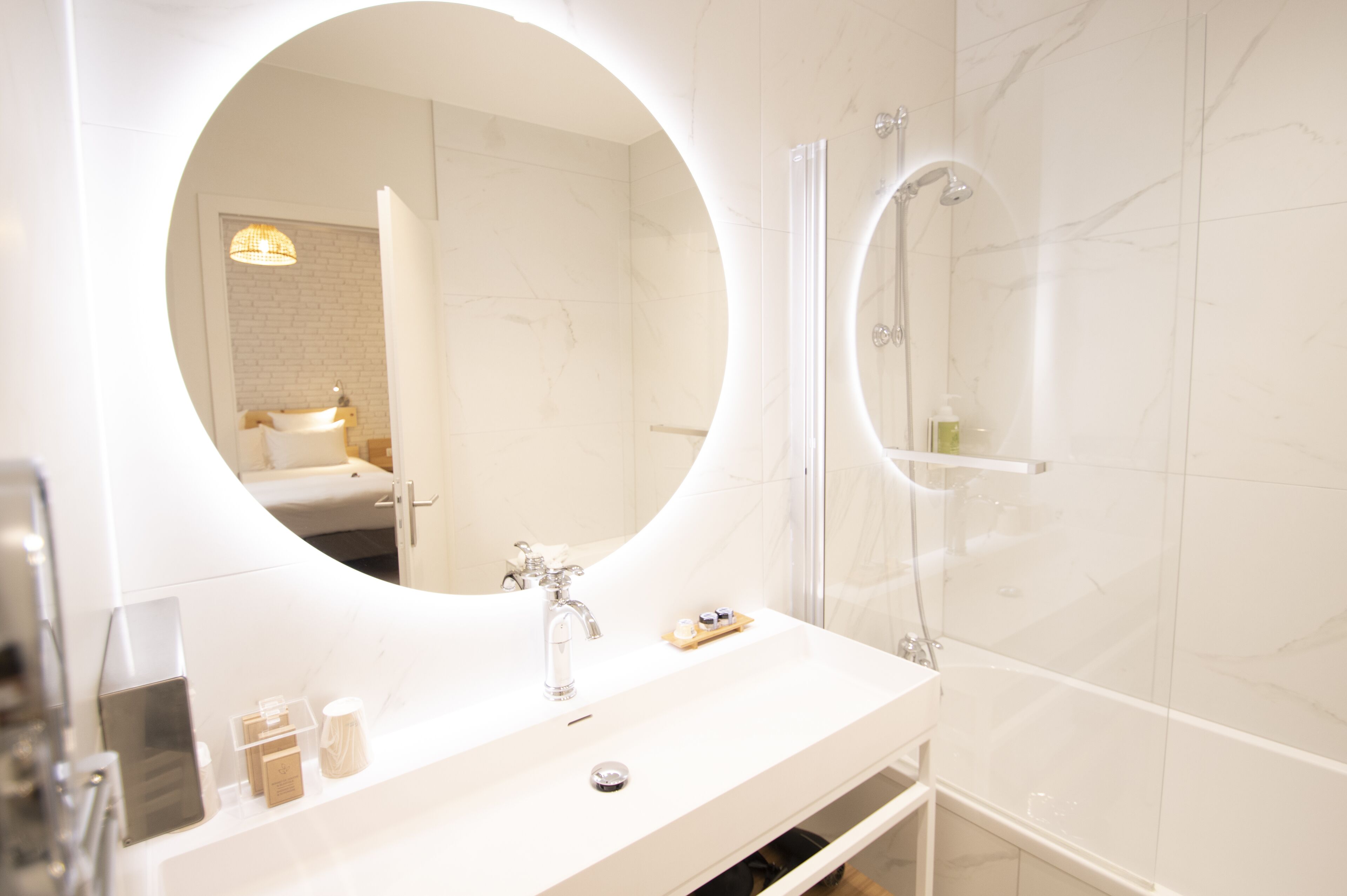 Ein modernes Badezimmer mit einem großen Spiegel, einer Badewanne und einer Dusche.