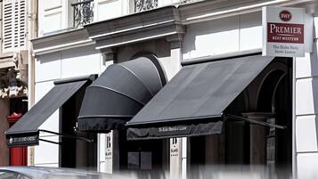 A building with awnings labeled "Premier Best Western The Blake Paris Saint-Lazare."