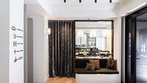 A modern hotel lobby with a seating area, a mirror reflecting the interior, and directional signage on the wall. - Best Western Premier The Blake Paris Gare Saint Lazare (Paris)