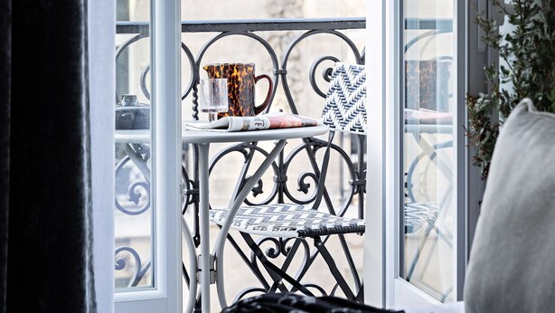A balcony with a wrought iron railing, a black and white striped pillow, and a plant on the right. - Best Western Premier The Blake Paris Gare Saint Lazare (Paris)