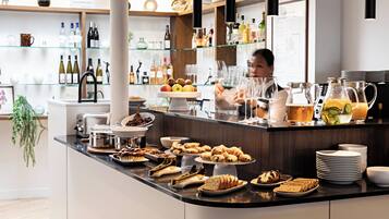 A buffet counter with various food items and beverages.