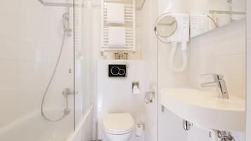 A modern bathroom with a glass-enclosed shower, a white toilet, a sink with a mirror, and a towel rack.