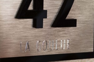 A wooden sign with the number "42" and the text "LA GOULUE" engraved in it.