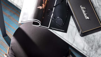 Uma revista, um par de óculos e um amplificador Marshall sobre uma mesa de mármore.