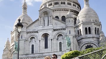 Un gran edificio blanco con cúpula, estatuas y una estatua de un hombre.