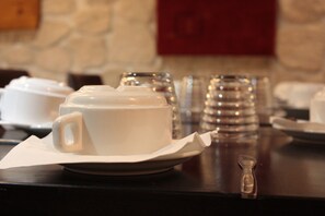 A table with a white cup and saucer, a glass, and a salt and pepper shaker. - Hotel Hauteville Opera (Paris)