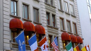 Edificio di un hotel con diverse bandiere, tra cui la bandiera canadese, e un cartello con la scritta "HOTEL RITZ".