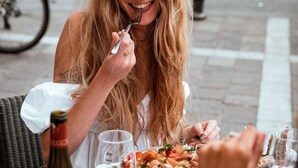 A dining table with a bottle of wine, a plate of food, and glasses. - Grand Tonic Hotel & SPA NUXE (Biarritz)