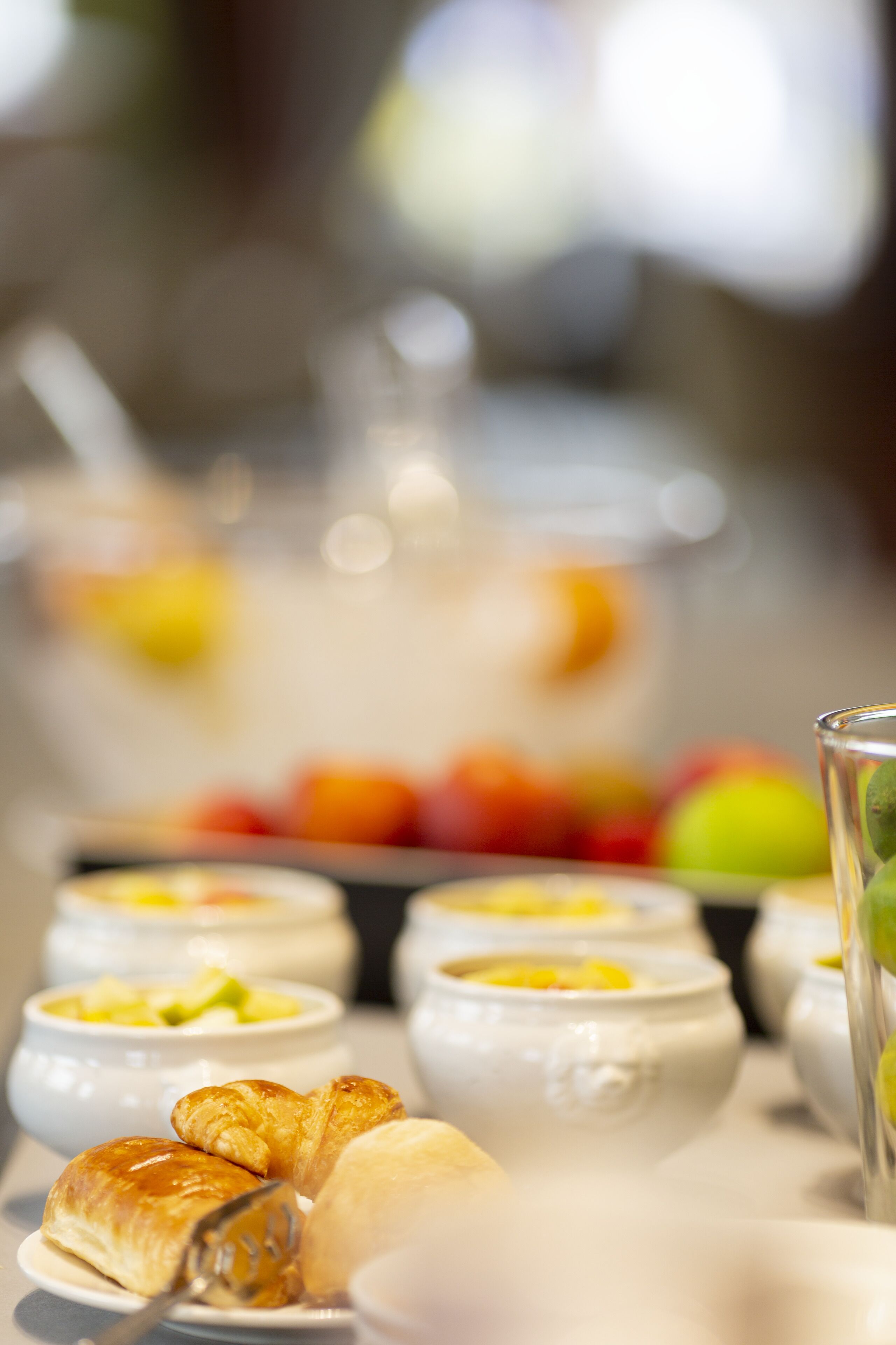 A breakfast buffet with various food items including pastries, fruits, and beverages.