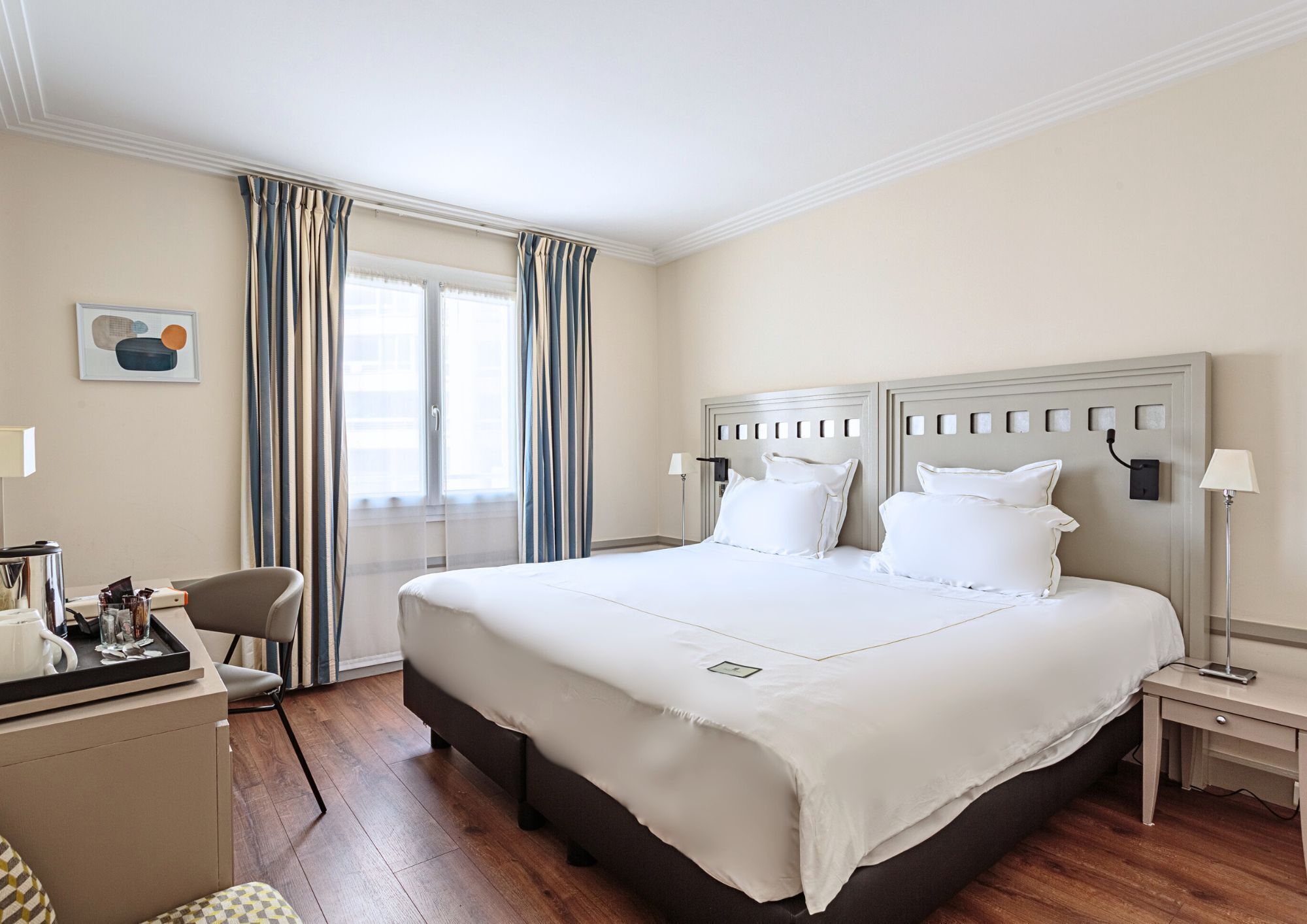 Une chambre d’hôtel avec un grand lit, un bureau et une chaise.