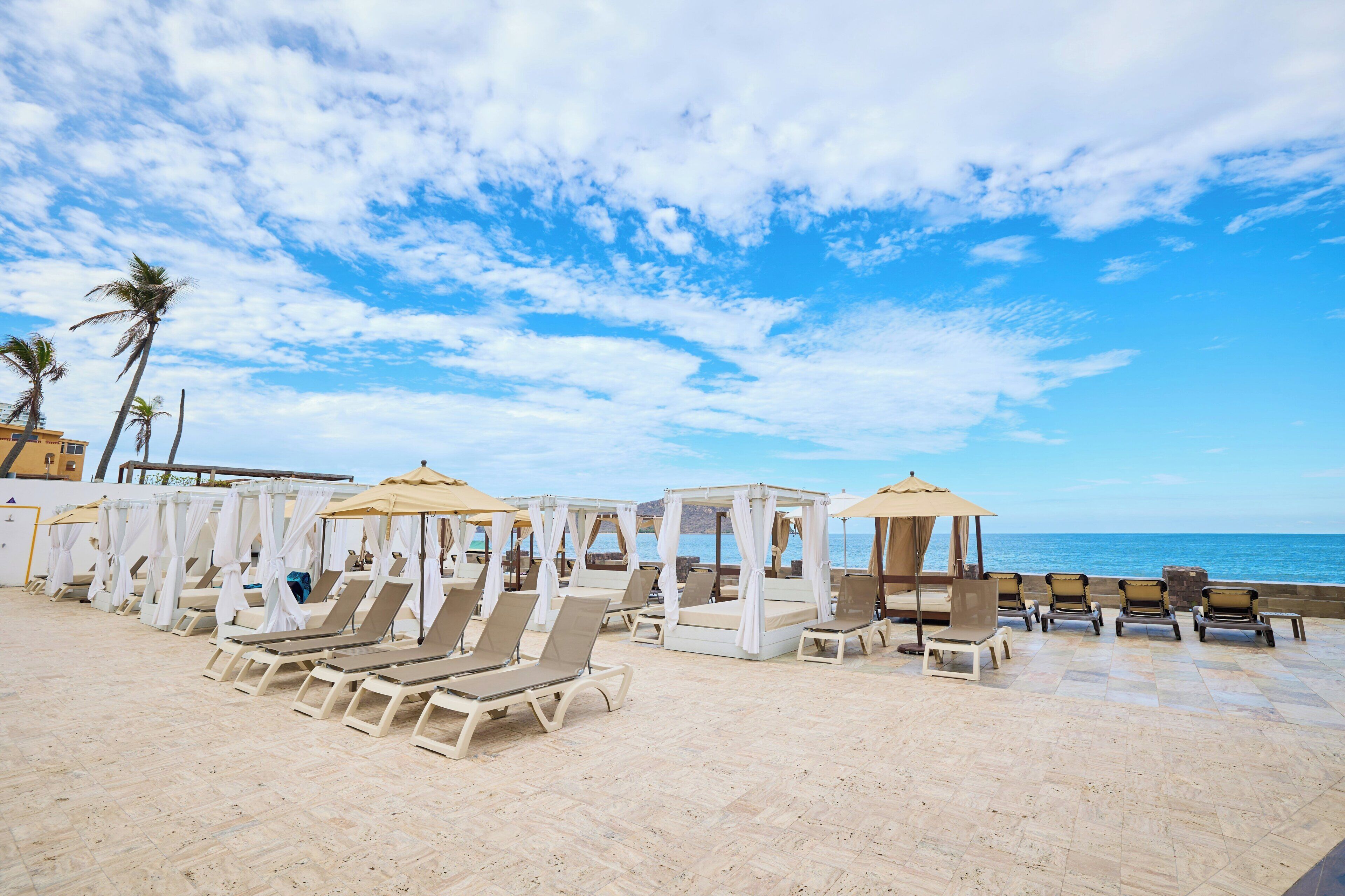 A beachside resort with sun loungers and cabanas.