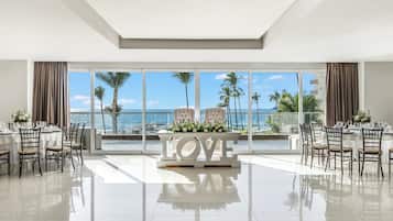 A spacious dining area with a view of the sea, a 'LOVE' centerpiece, and a modern interior design.