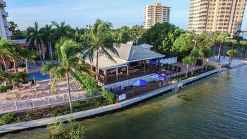 A waterfront restaurant with outdoor seating, a covered patio, and a view of the water.