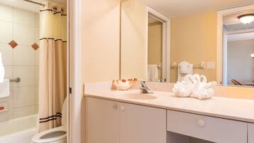 A bathroom with a bathtub, toilet, sink, and a large mirror.