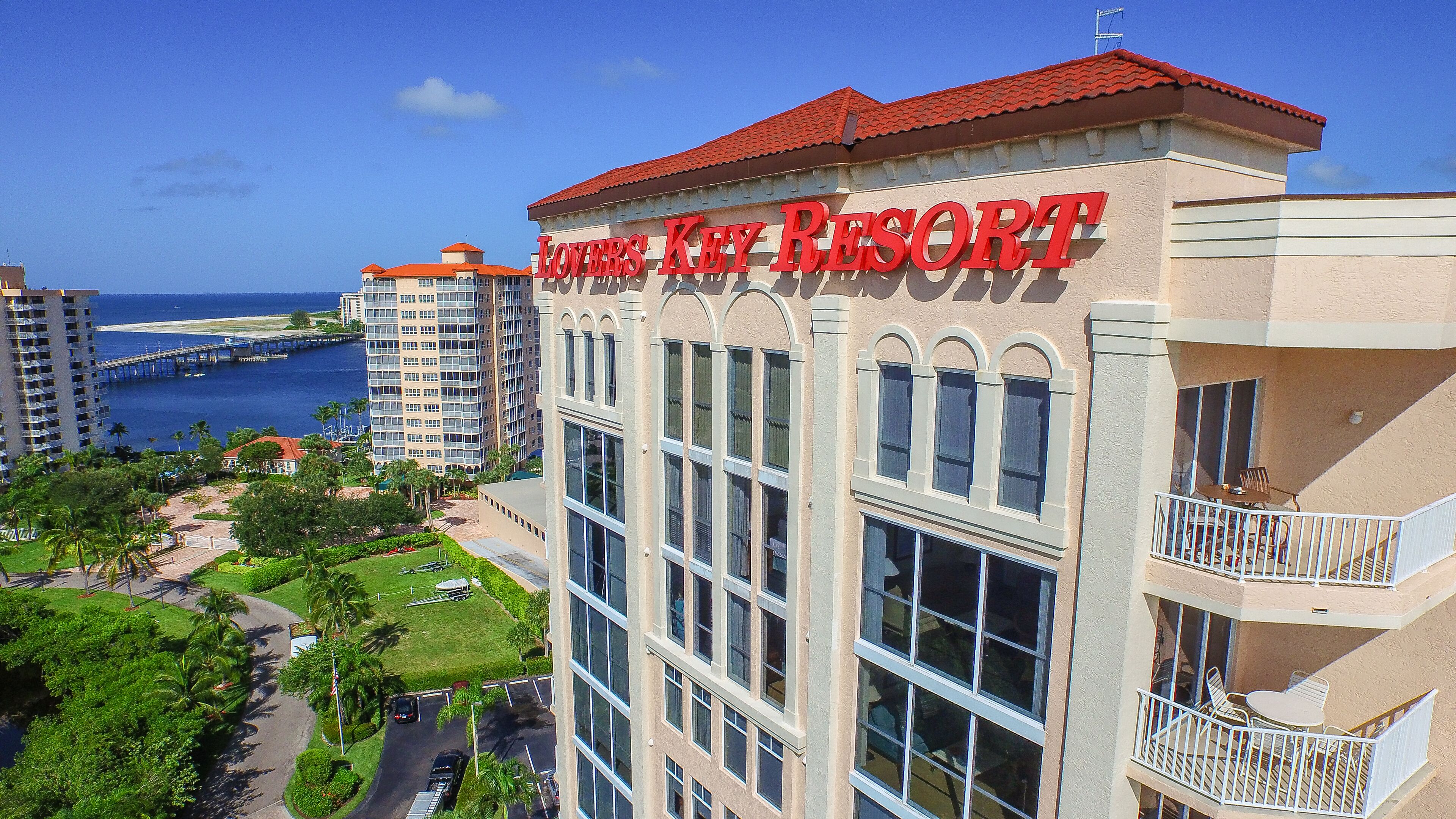 A hotel named 'Lovers Key Resort' with a view of the ocean and a bridge in the background.