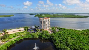 A high-rise hotel with a central courtyard, surrounded by lush greenery and a body of water. - Lovers Key Resort (Fort Myers Beach)