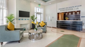 A lobby with a reception desk, seating area, and a fireplace. - Hilton Vacation Club Crescent on South Beach Miami (Miami Beach)