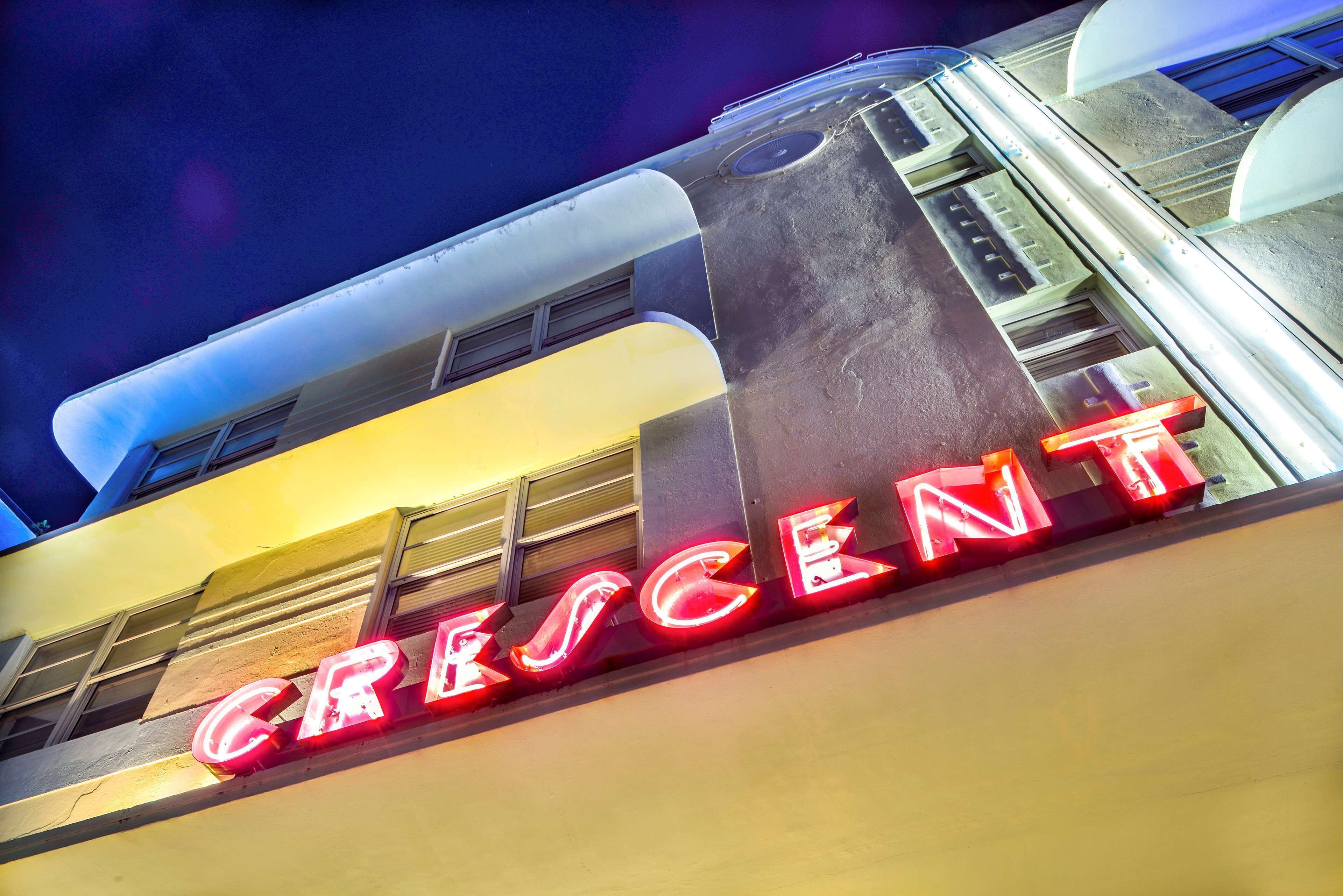 A building with a neon sign spelling "CRESCENT" in red letters.