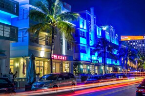 A hotel with a prominent 'RESIDENT' sign, palm trees, and a 'Royal Palm' sign in the background. - Hilton Vacation Club Crescent on South Beach Miami (Miami Beach)