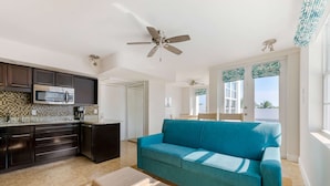 A modern kitchen with dark cabinets, a microwave, and a ceiling fan. - Hilton Vacation Club Crescent on South Beach Miami (Miami Beach)