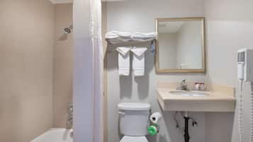 A bathroom with a bathtub, toilet, sink, and a mirror.