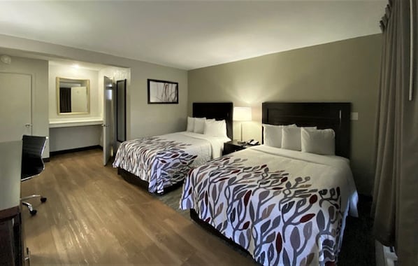 A hotel room with two beds, a desk, a chair, a mirror, and a framed picture on the wall. - Red Roof Inn Tucson Downtown – University (Tucson)