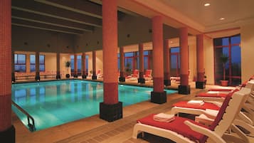 Una piscina techada, sillones reclinables de piscina