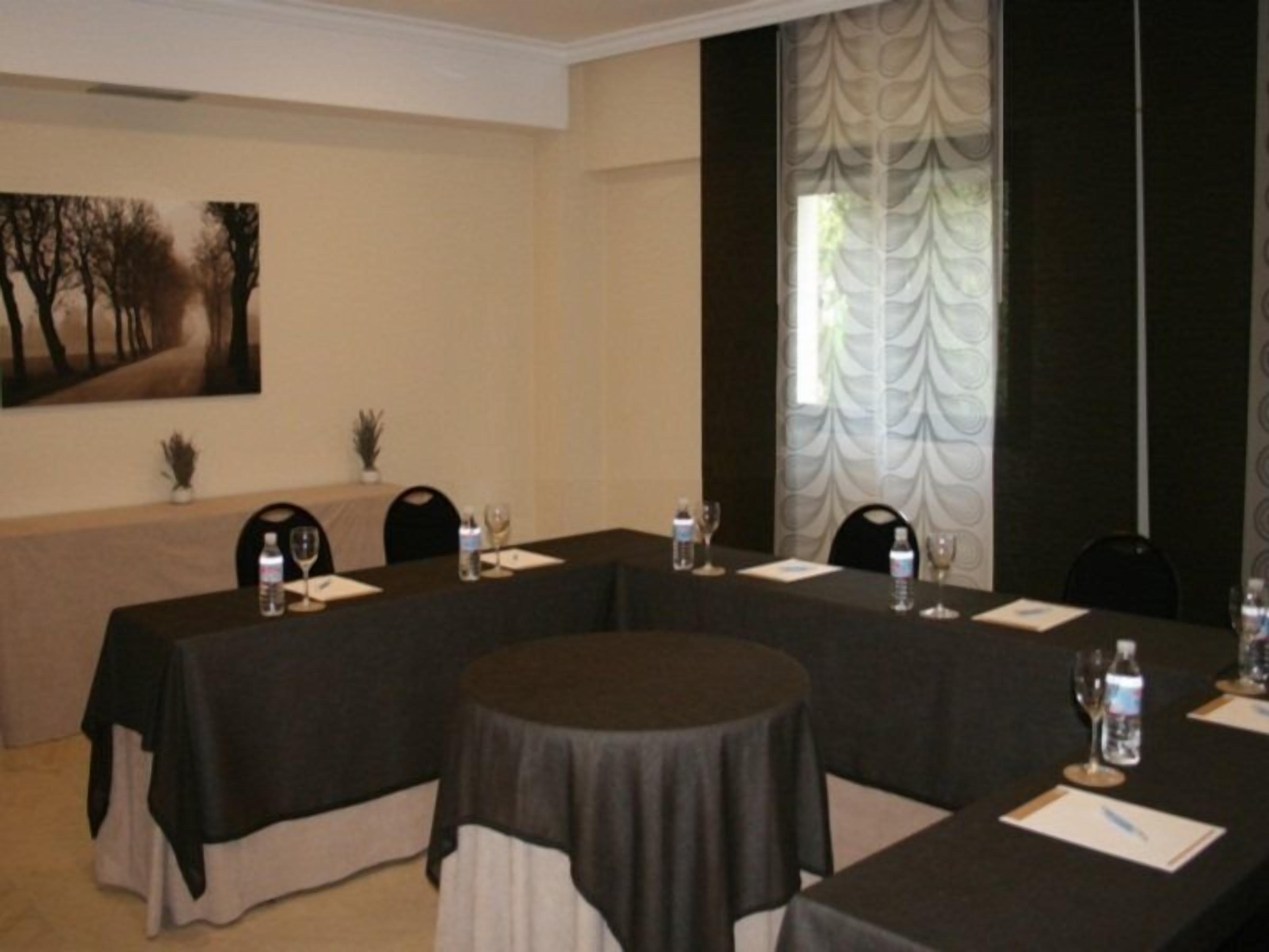 A conference room with a long table, chairs, water bottles, and glasses.