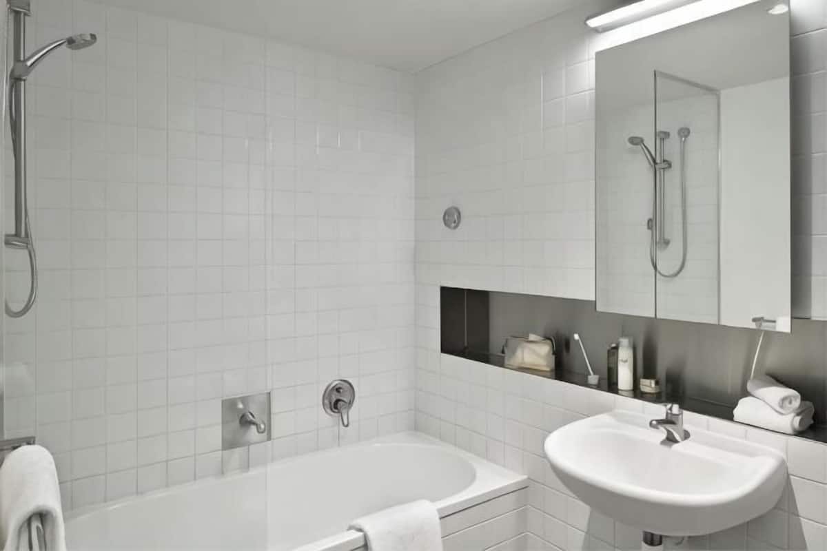 A modern bathroom with a bathtub, a sink, a mirror, and a shower.
