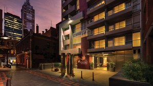 A modern hotel with a prominent entrance, multiple floors, and a well-lit facade. - Punthill Little Bourke (Melbourne)