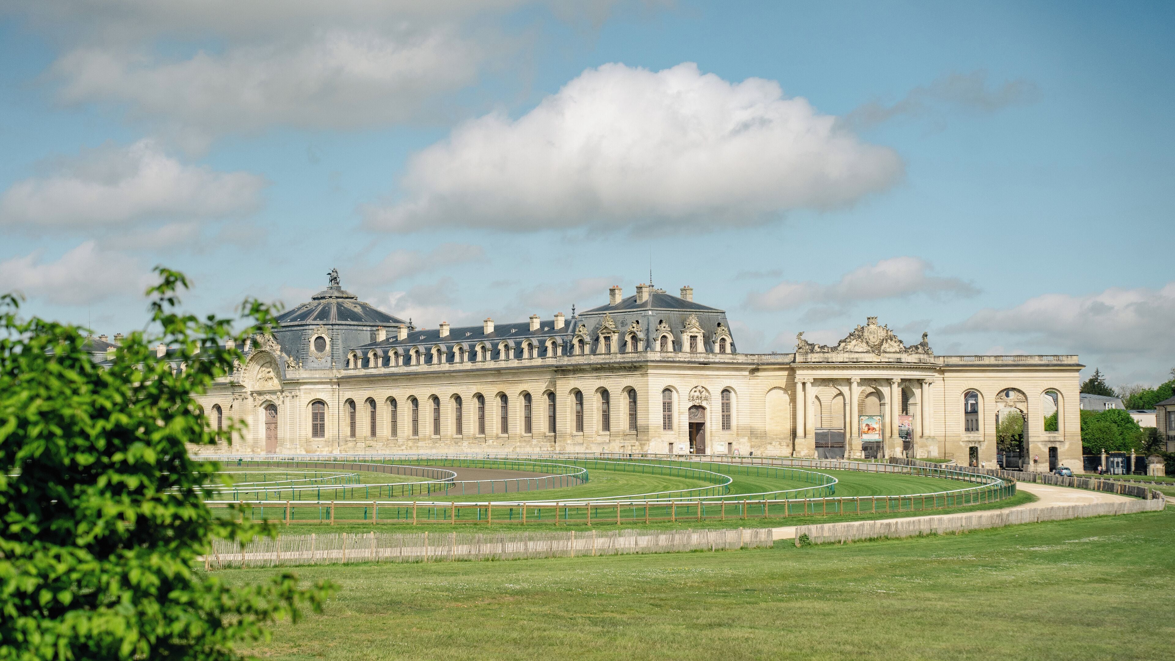 A large historic building with a symmetrical facade, arched windows, and a central dome.