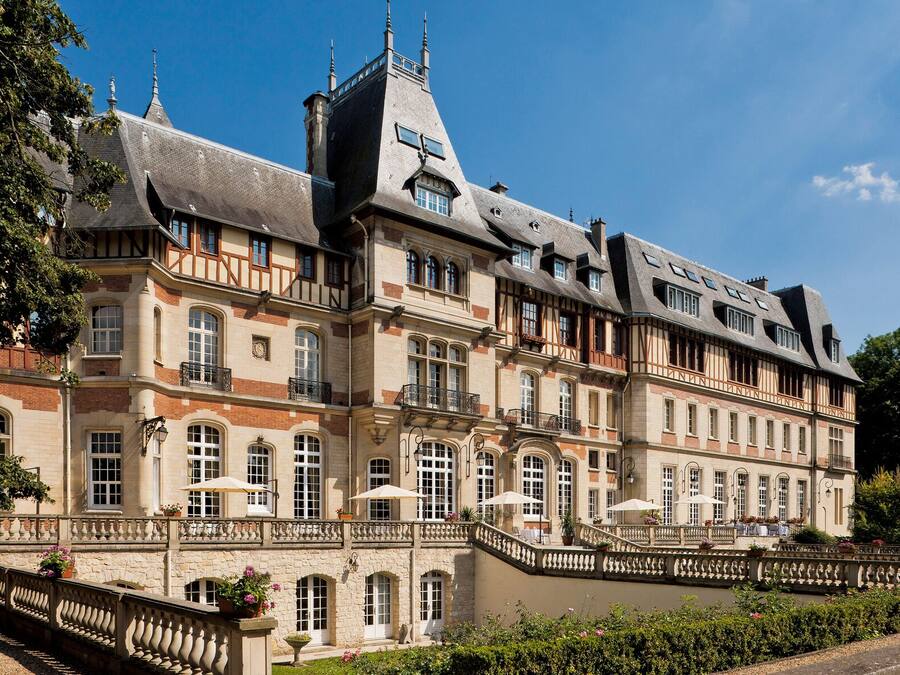 Ein großes, historisches Gebäude mit mehreren Stockwerken, das durch einen markanten, zentralen Turm und eine symmetrische Fassade mit zahlreichen Fenstern und Balkonen gekennzeichnet ist.