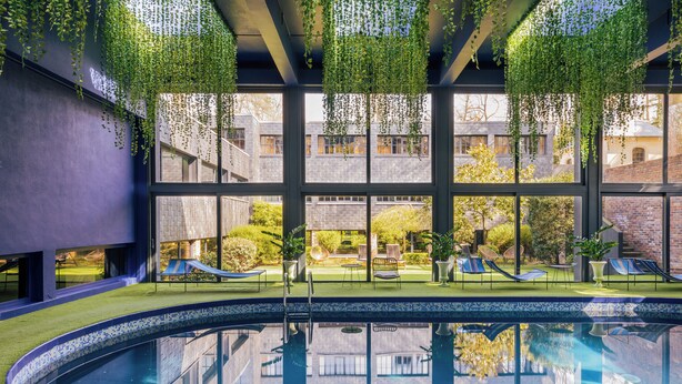 A swimming pool with a tiled edge, surrounded by a grassy area and lounge chairs. - Château Jeanne & the Forest - Château de Montvillargenne (Gouvieux)