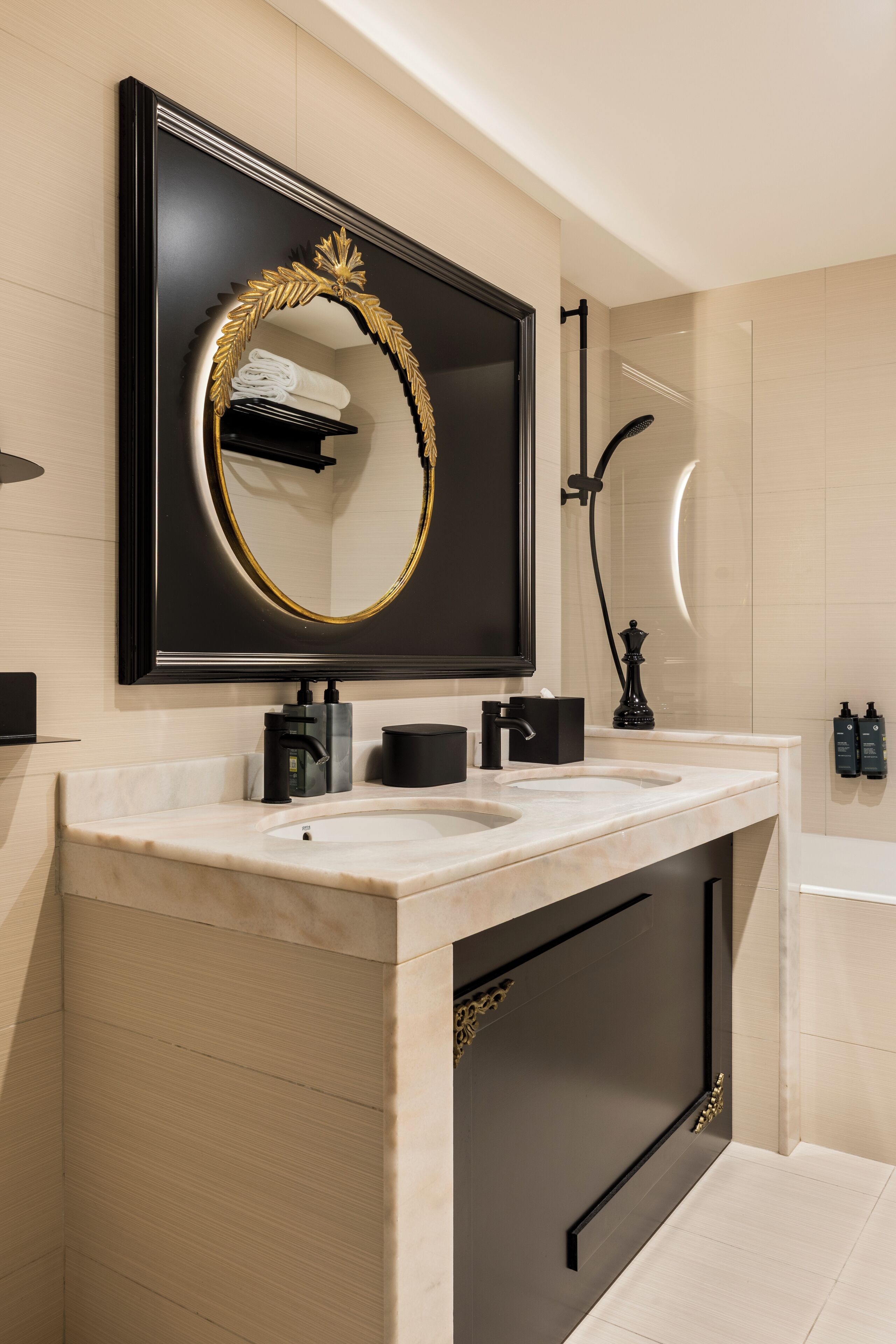 A modern bathroom with a large mirror, two sinks, a shower, and a towel rack.