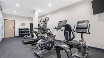 A gym with treadmills, elliptical machines, and free weights.