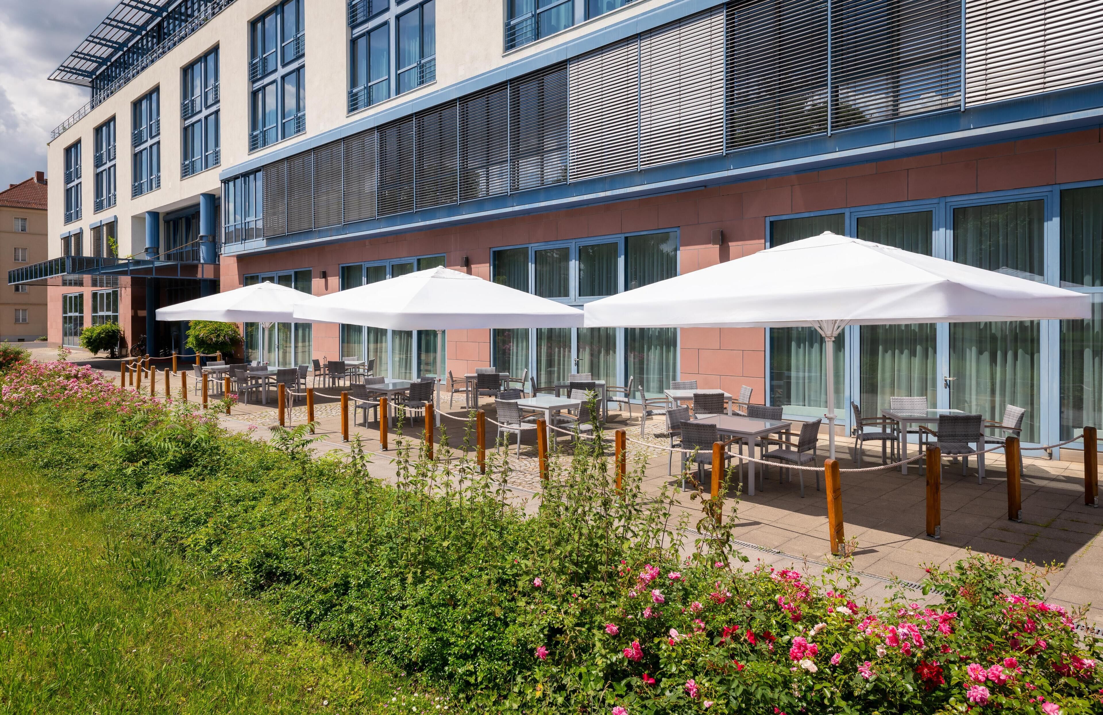 Un hotel con posti a sedere all'aperto e un giardino.