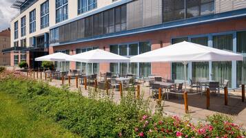 Un hotel con posti a sedere all'aperto e un giardino.