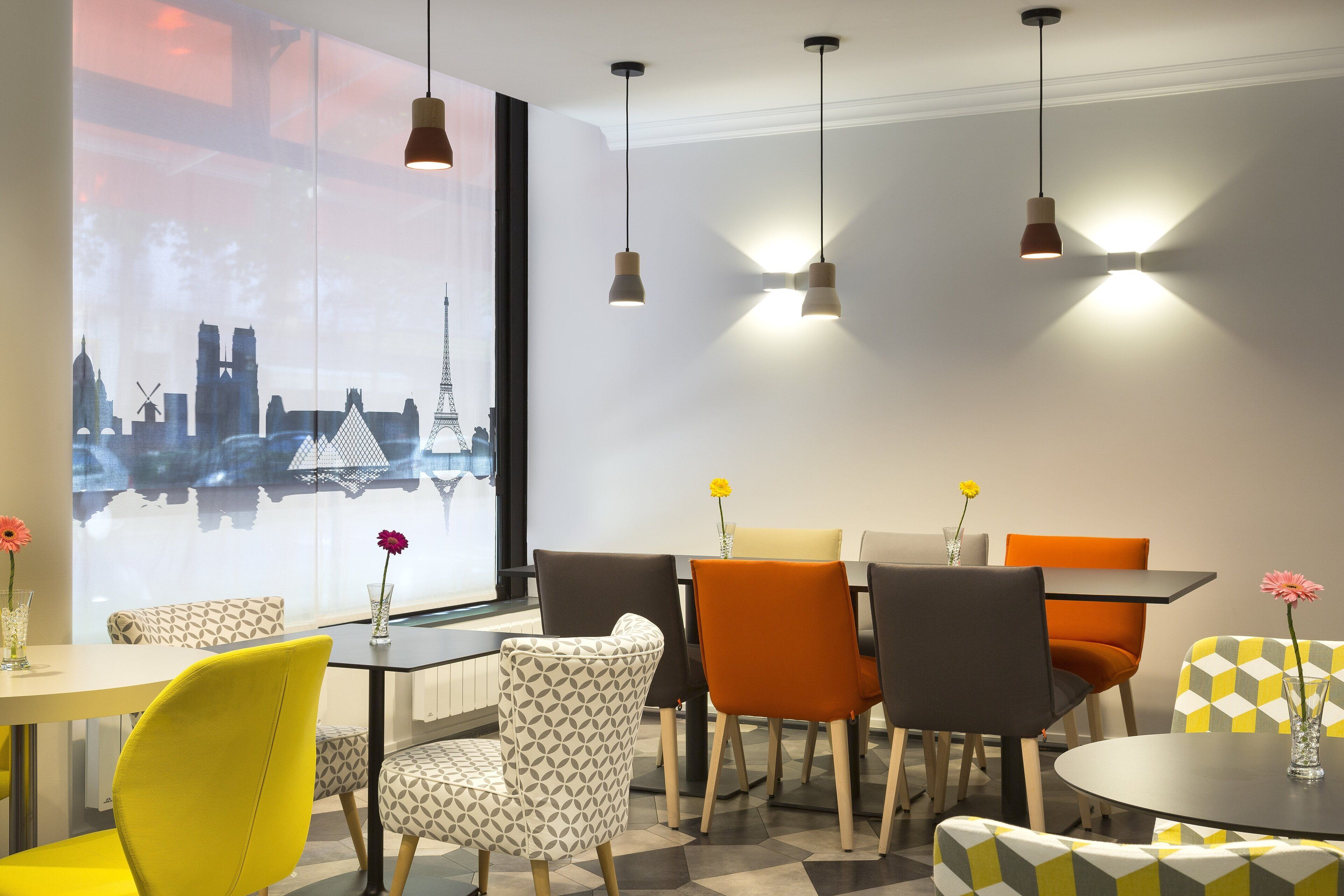 A modern dining area with patterned chairs, a table, and pendant lighting.
