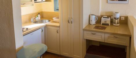 A compact kitchen with a sink, microwave, toaster, and coffee maker.