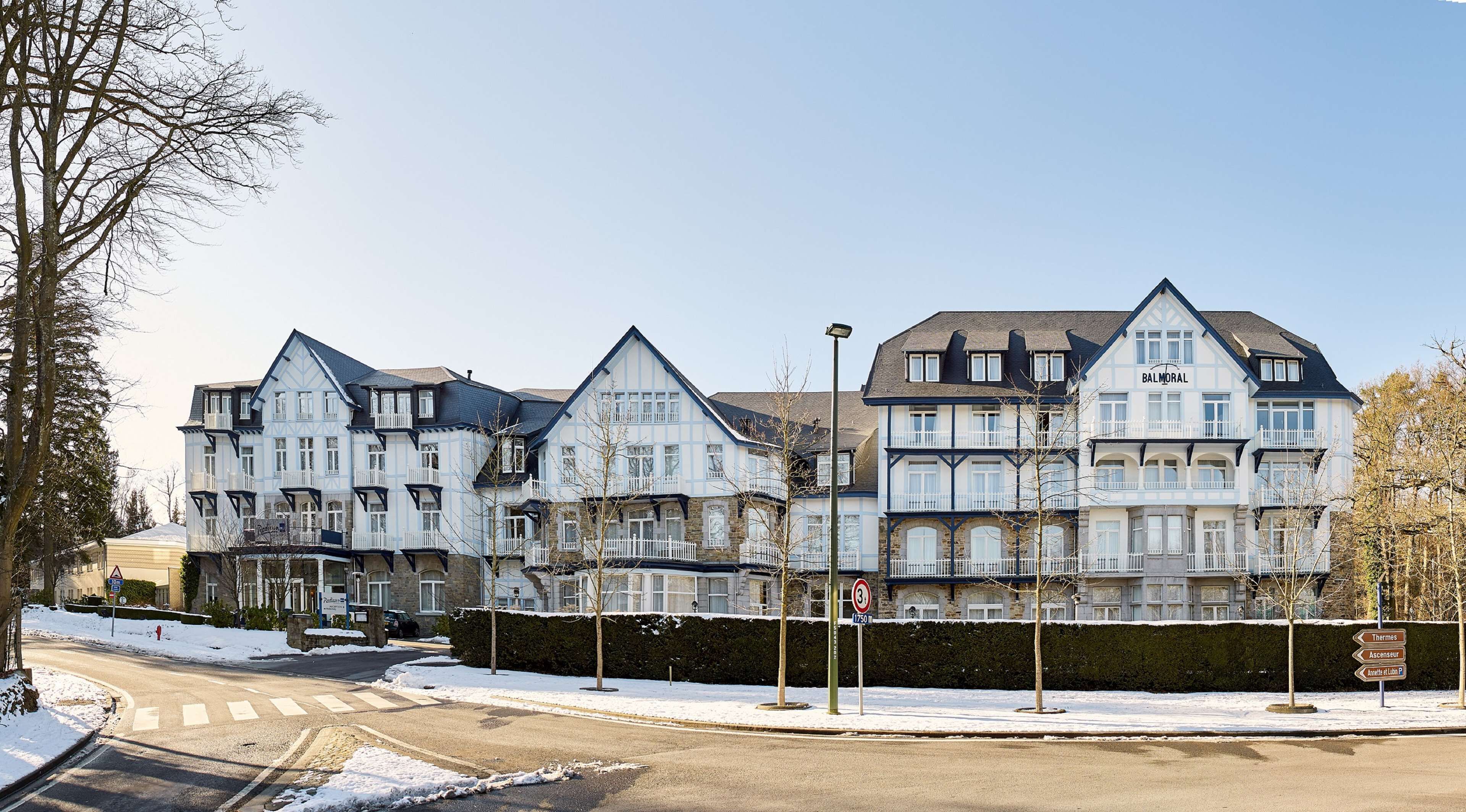 A row of traditional European-style townhouses with multiple stories, large windows, and balconies.
