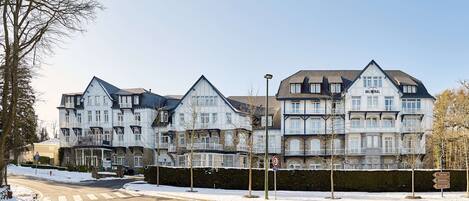 A row of traditional European-style townhouses with multiple stories, large windows, and balconies.