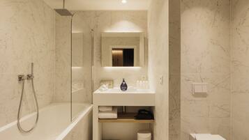 Une salle de bain moderne avec une baignoire sur pieds, une douche à parois de verre et un meuble-lavabo avec un miroir.