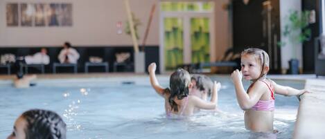 An indoor swimming pool with children playing.