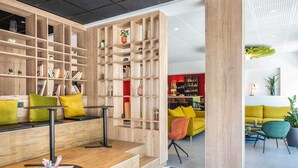 A modern interior with a wooden bookshelf, seating area, and a bar.